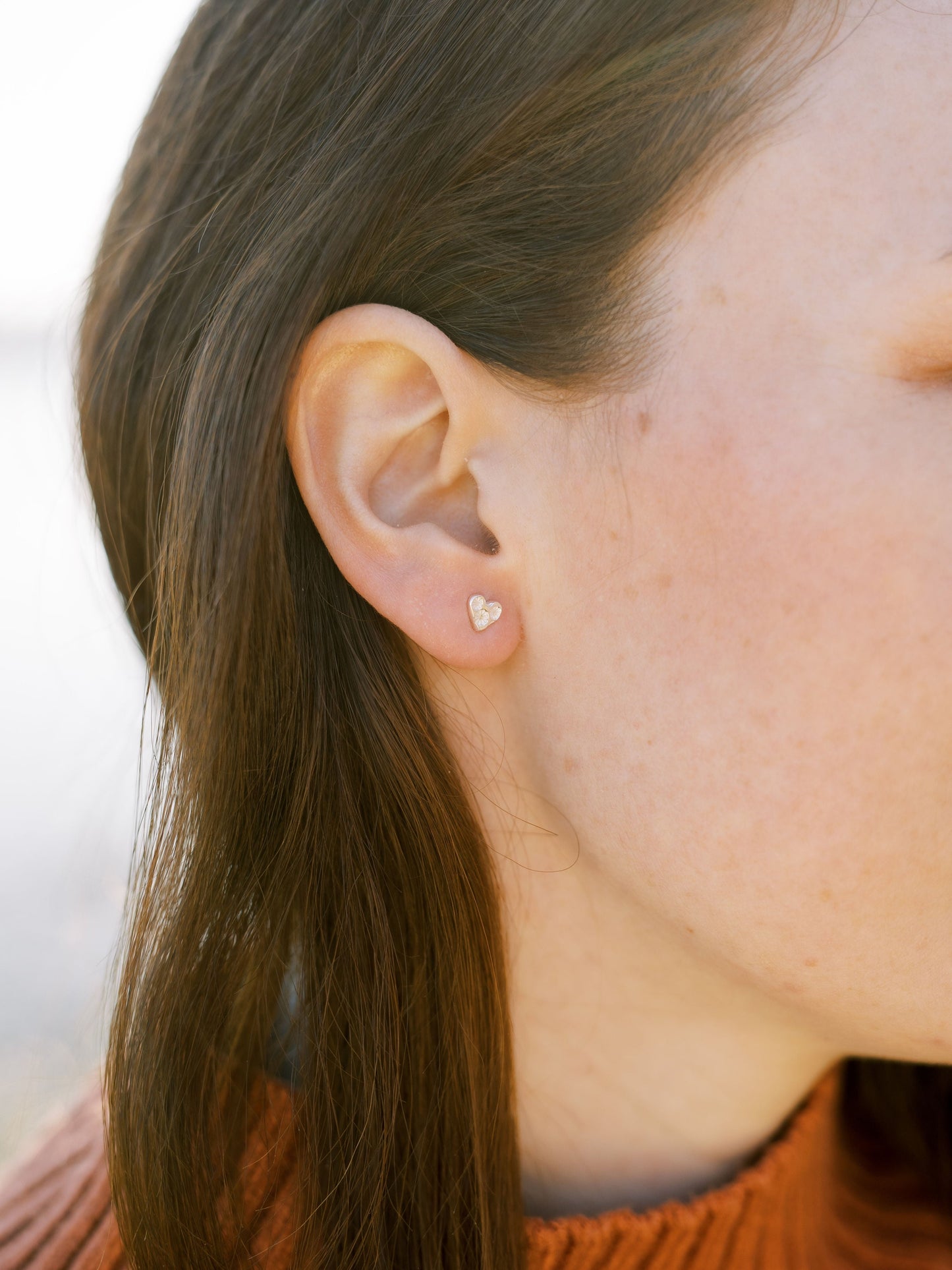 Model wearing Elin Mair heart studs in silver
